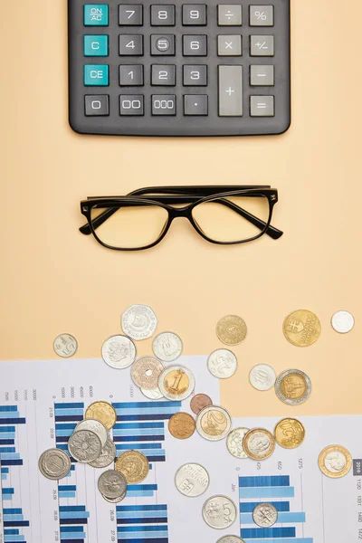 Vista superior de papéis, calculadora, moedas e óculos na mesa — Fotografia de Stock