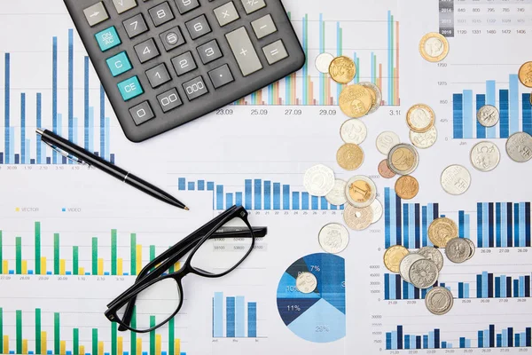 Vista superior de papeles, bolígrafo, calculadora, monedas y vasos en la mesa - foto de stock