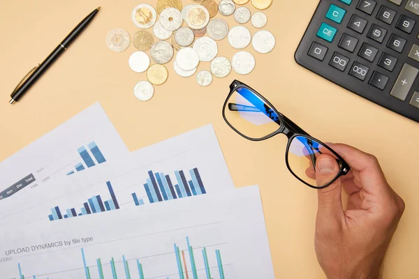 Vista recortada del hombre adulto sosteniendo gafas en la oficina - foto de stock