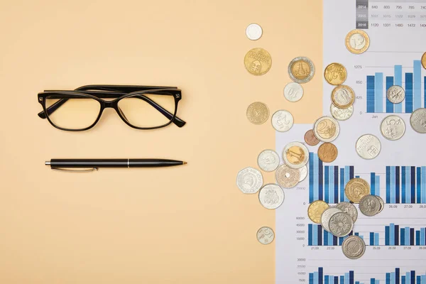 Top view of papers, pen, coins and glasses on table — Stock Photo