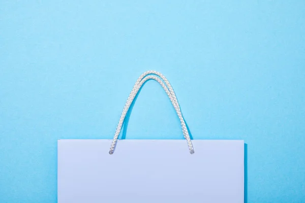 Top view of purple shopping bag on blue — Stock Photo