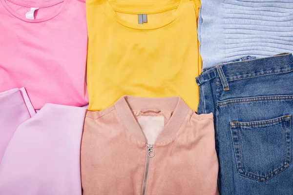 Plat avec des t-shirts colorés, jeans, chapeau et veste — Photo de stock