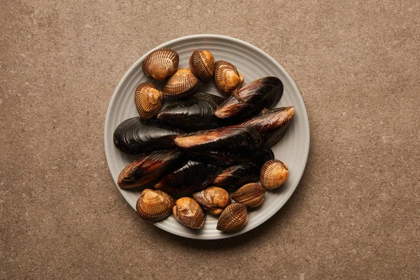 Vue de dessus de la plaque avec des coques et des moules non cuites à la surface — Photo de stock