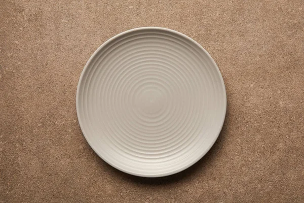 Top view of empty white plate on textured surface — Stock Photo