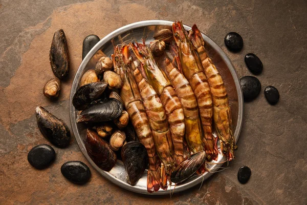Vista dall'alto di molluschi, cockles e cozze in ciotola su superficie testurizzata — Foto stock