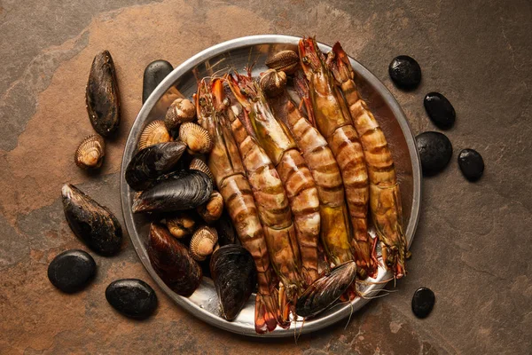 Vue de dessus des coquillages, des coques et des moules dans un bol sur une surface texturée — Photo de stock