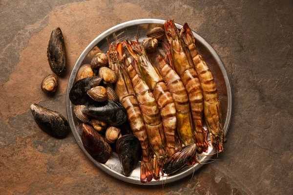 Vista superior de moluscos com conchas e mexilhões em tigela na superfície texturizada — Fotografia de Stock