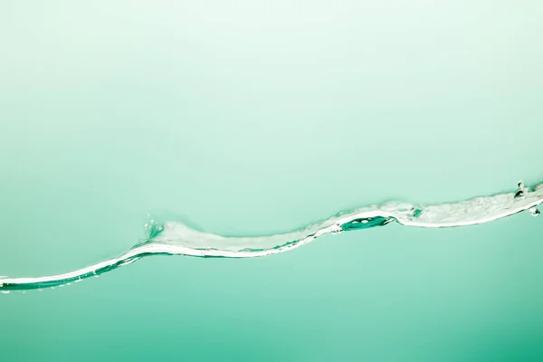 Agua pura transparente con salpicaduras y cubitos de hielo sobre fondo azul - foto de stock