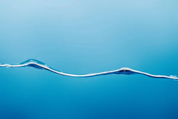 Волнистая чистая вода на синем фоне — стоковое фото