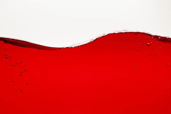 Волнистая красная яркая жидкость с пузырьками, изолированными на белом — стоковое фото