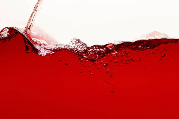 Flowing red bright liquid with splash and bubbles isolated on white — Stock Photo