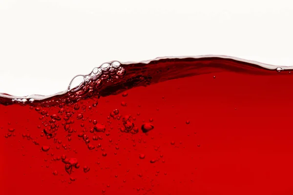 Rouge liquide brillant avec onde et bulles isolées sur blanc — Stock Photo