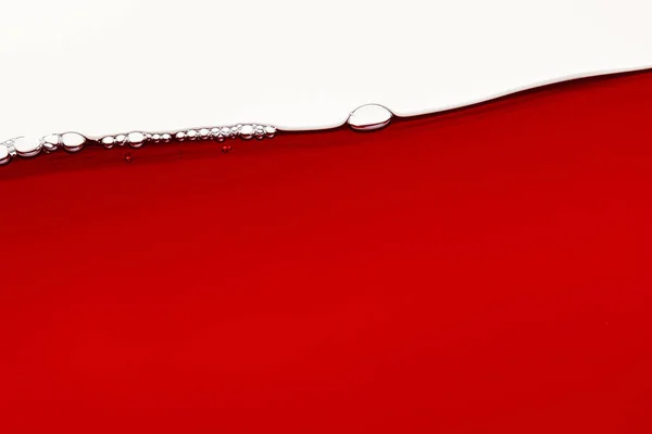 Red bright liquid with bubbles on surface isolated on white — Stock Photo