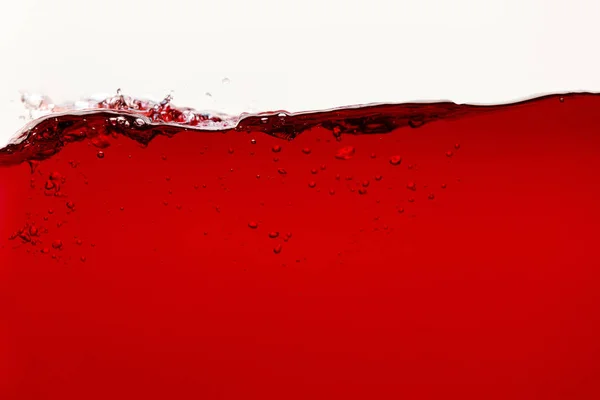 Liquide brillant rouge avec bulles isolées sur blanc — Photo de stock