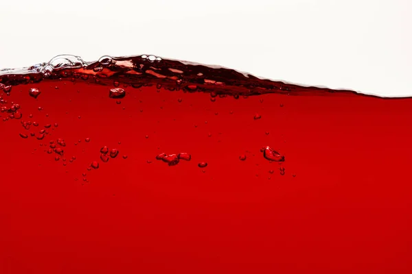 Liquide rouge vif ondulé avec bulles isolées sur blanc — Stock Photo