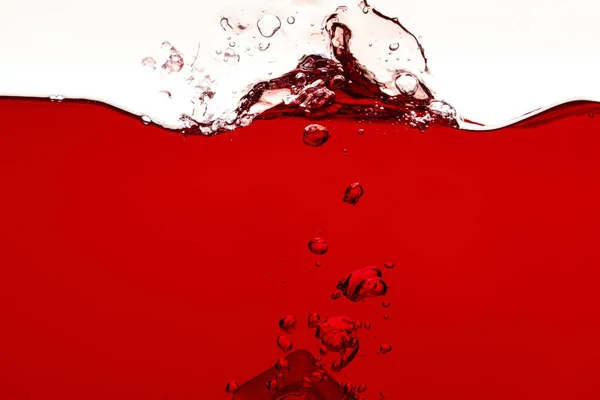 Liquido rosso con spruzzi e bolle isolate su bianco — Foto stock