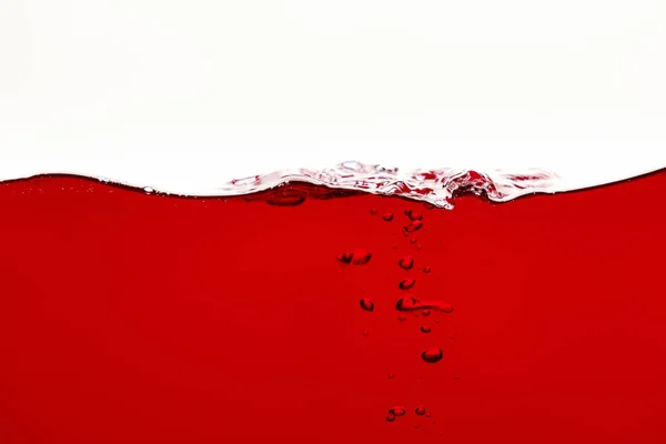 Liquido rosso brillante con bolle subacquee isolate su bianco — Foto stock