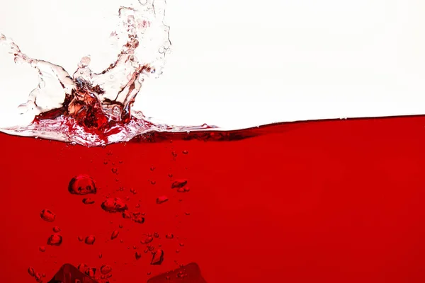 Red bright liquid with splash and bubbles isolated on white — Stock Photo