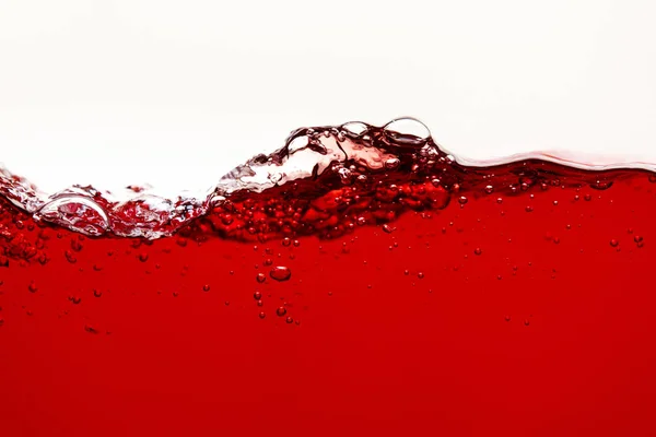 Rote helle Flüssigkeit mit Spritzern und Blasen isoliert auf weiß — Stockfoto