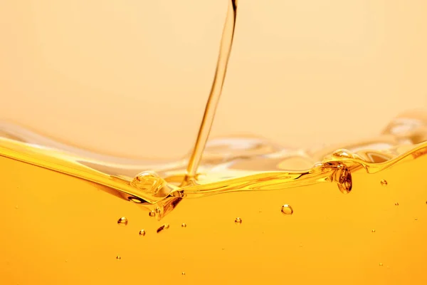 Ruscello liquido giallo brillante con spruzzi e bolle isolate su giallo — Foto stock