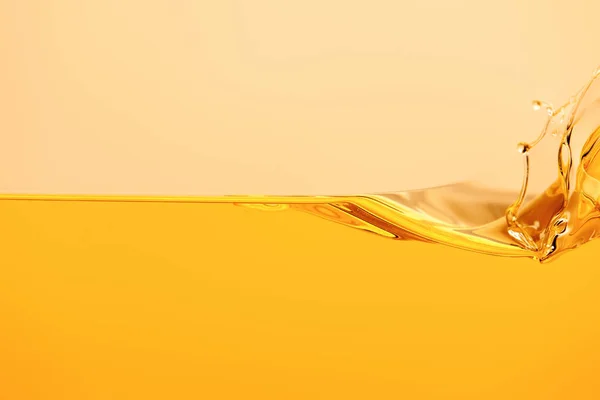 Yellow bright liquid splash isolated on yellow — Stock Photo