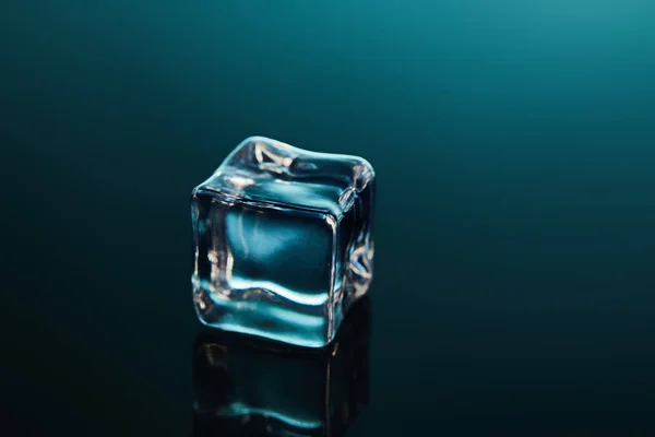 Pure transparent ice cube on emerald background — Stock Photo