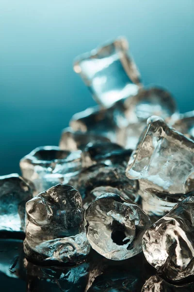 Selektiver Fokus transparenter Eiswürfel auf smaragdgrünem Hintergrund — Stockfoto