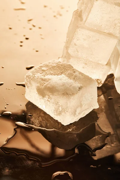 Stack of ice cubes with puddles on surface with reflection — Stock Photo