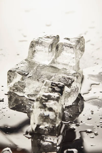 Чистые тающие кубики льда с капельками и лужами на поверхности — стоковое фото