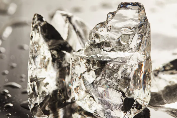 Vista de cerca de cubos de hielo de fusión pura con gotas - foto de stock