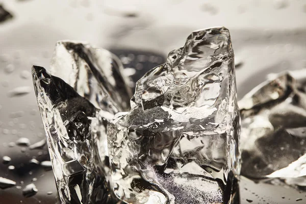 Vue rapprochée des cubes de glace fondus purs avec des gouttes — Photo de stock