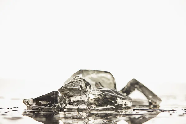 Pilha de cubos de gelo fundidos transparentes no fundo branco — Fotografia de Stock