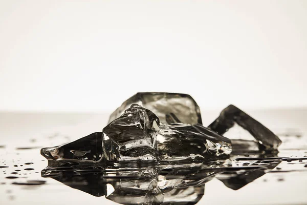 Pile de glaçons transparents fondus sur fond blanc — Photo de stock