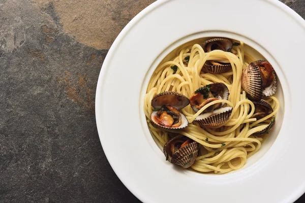 Draufsicht auf köstliche Pasta mit Weichtieren auf verwittertem grauen Hintergrund — Stockfoto