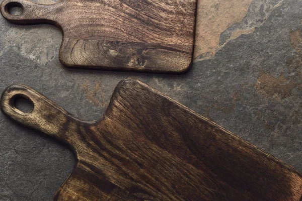 Vista superior de tablas de cortar de madera marrón sobre fondo gris envejecido - foto de stock