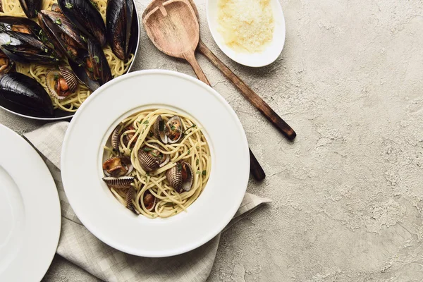 Draufsicht auf köstliche Pasta mit Meeresfrüchten und geriebenem Käse auf verwittertem grauem Hintergrund mit Kopierraum — Stockfoto