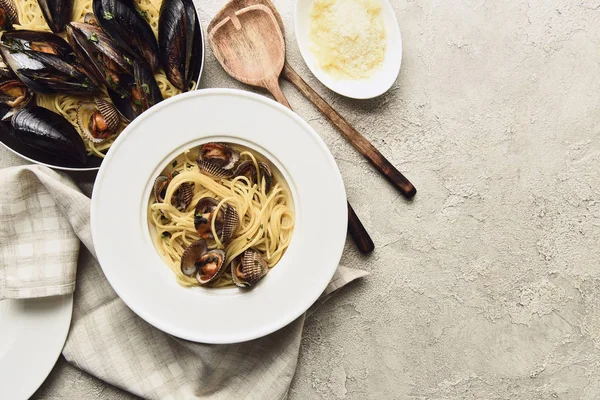 Top view of tasty pasta with seafood and grated cheese on weathered grey background with copy space — Stock Photo