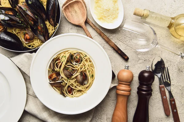 Blick von oben auf leckere Pasta mit Meeresfrüchten, serviert mit geriebenem Käse und Weißwein — Stockfoto