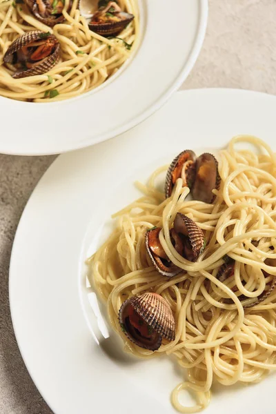Close up view of delicious pasta with seafood served in two white plates — Stock Photo