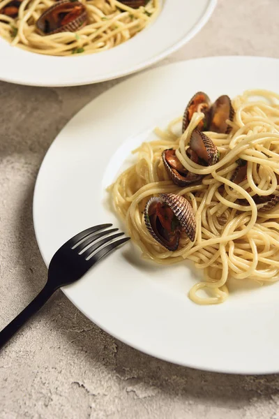 Nahaufnahme von köstlichen Pasta mit Meeresfrüchten serviert in zwei weißen Tellern mit Gabel — Stockfoto