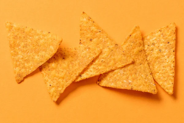 Vista superior de deliciosos nachos mexicanos crujientes tradicionales sobre fondo naranja - foto de stock