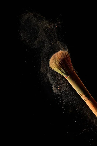 Cosmetic brush with light powder on black background — Stock Photo