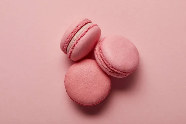 Tasty sweet pink french macaroons on pink background — Stock Photo