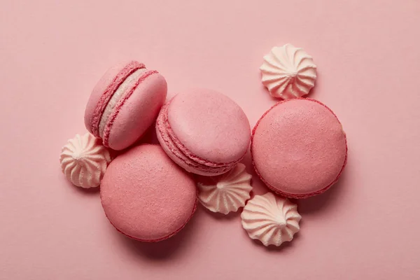 Macaroni rosa con meringhe rosa su sfondo rosa — Foto stock