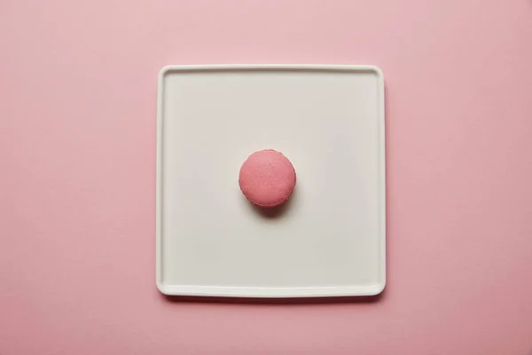 Top view of pink macaroon on big square white dish on pink background — Stock Photo