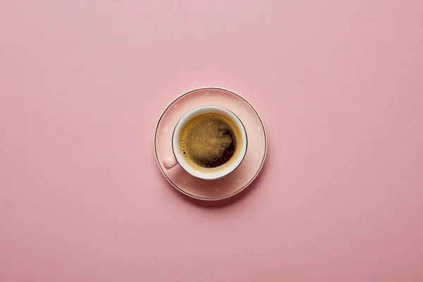 Cup of aromatic coffee at pink saucer with white dots on pink background — Stock Photo