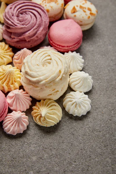 Delicious assorted soft zephyr, small meringues and macaroons on gray background — Stock Photo