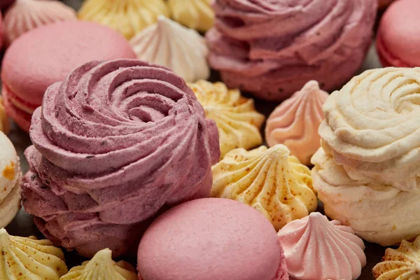 Zéphyr rose et blanc avec petites meringues jaunes et roses et macarons roses français — Photo de stock