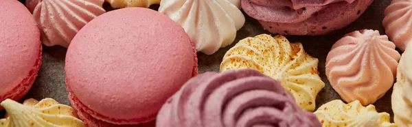 Macarons gourmands roses sucrés, assortis de petites meringues et de zéphyr sur fond gris — Photo de stock
