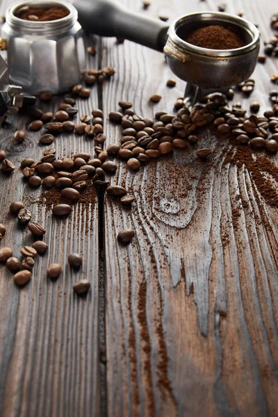 Portafiltro vicino alla caffettiera geyser su una superficie di legno scuro con chicchi di caffè — Foto stock
